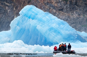 Inflatable boat near a recently calved iceberg from South Sawyer Glacier in Southeast Alaska.