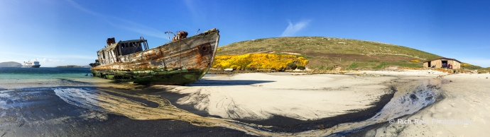 Panorama of the shipwrecked sealing vessel, the Protector III In front of the Barnard House on New Island in the Falkland Islands.